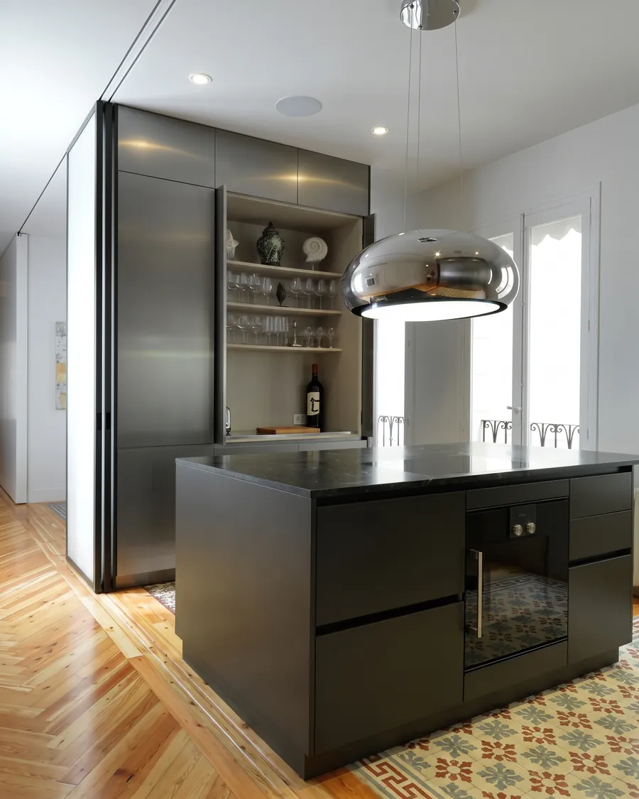 Cocina en negro con isla, campana de acero y suelo de espiga
